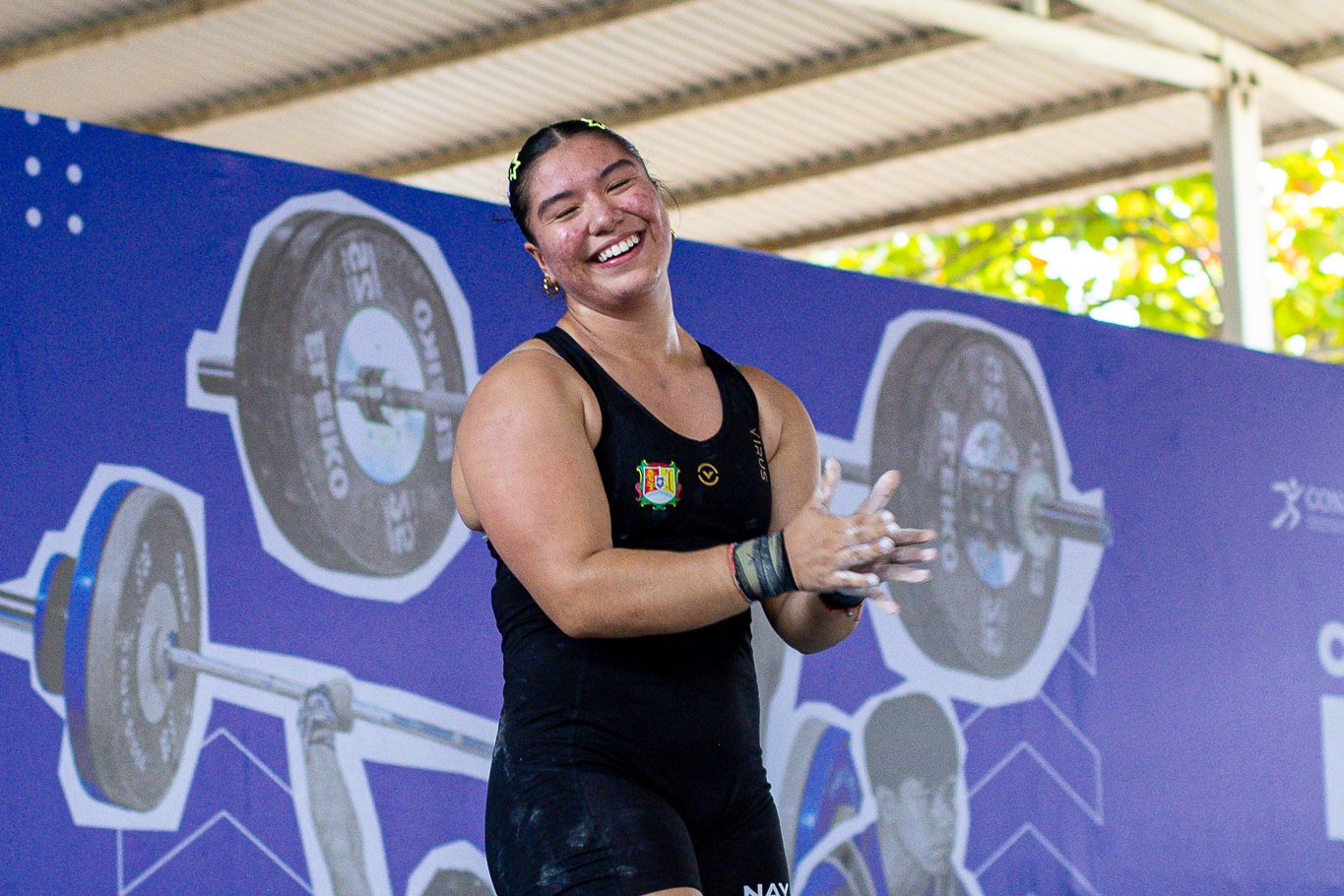 Atleta de halterofilia sonriendo en plena competencia